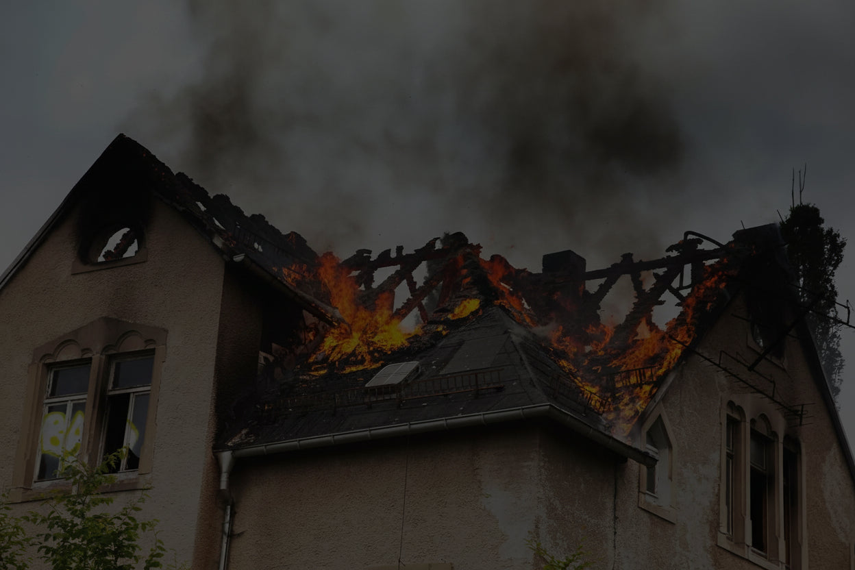 House on fire with flames and smoke billowing from the roof